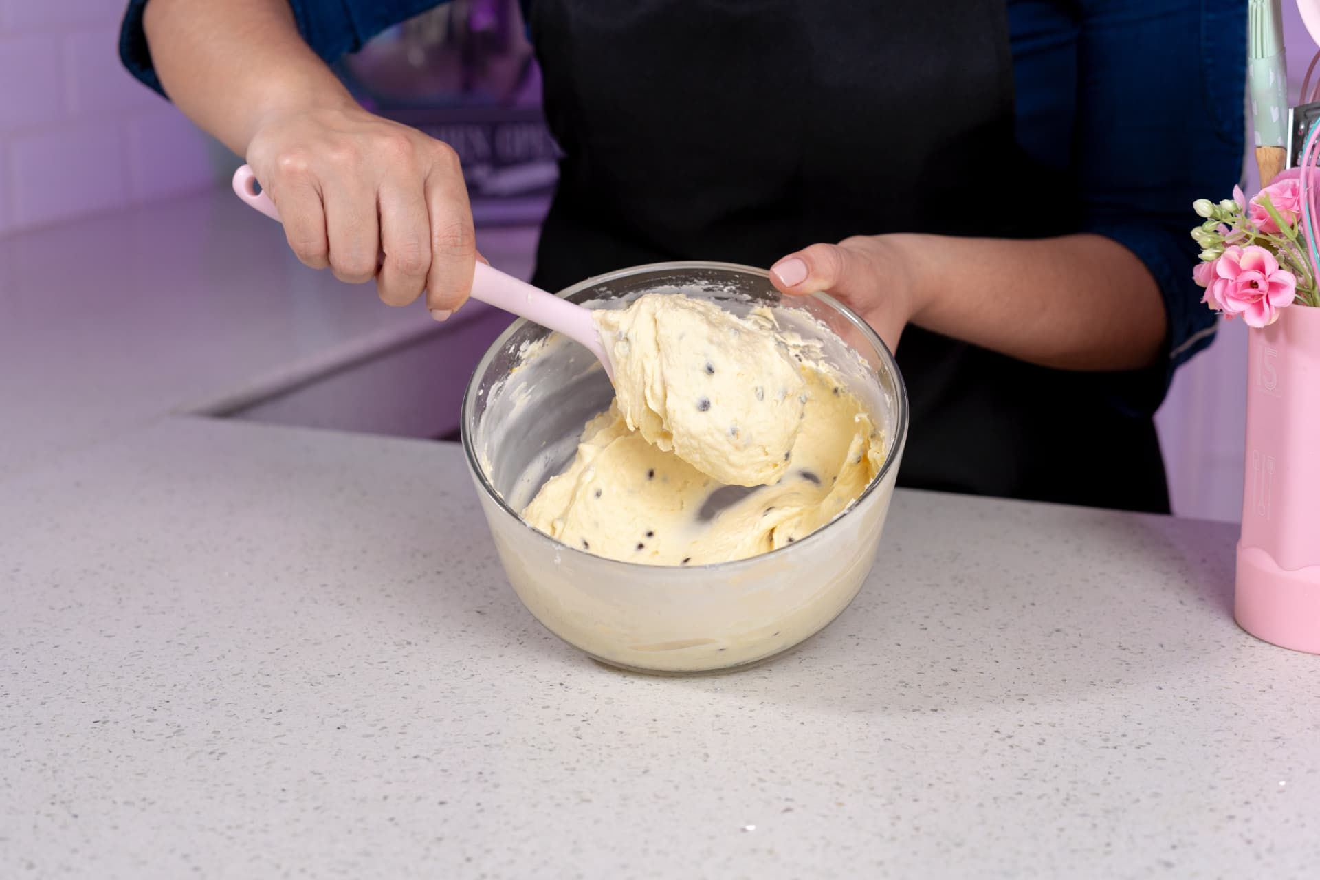 Bel García trabajando el ganache en un bowl de cristal, levantando la mezcla con una espátula para mostrar su textura y consistencia